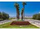 A picturesque entrance to Summerlin with lush landscaping and tall palm trees against a backdrop of scenic mountains at 11398 Belmont Lake Dr # 104, Las Vegas, NV 89135