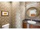 Stylish powder room with unique wallpaper, decorative mirror and dark stone countertop vanity at 11398 Belmont Lake Dr # 104, Las Vegas, NV 89135