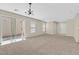 Spacious living room with neutral carpet, a sliding glass door, and modern lighting at 11934 Wild Chamomile St, Las Vegas, NV 89183