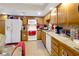 Galley kitchen with wood cabinets, granite countertops, and white appliances at 1312 Rawhide St, Las Vegas, NV 89119