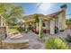 Spacious backyard featuring a stone fireplace, covered patio, and lush landscaping at 1432 Castle Crest Dr, Las Vegas, NV 89117