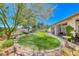 Lush backyard features a well-maintained lawn, mature trees, stone pathway, and a tranquil setting at 1432 Castle Crest Dr, Las Vegas, NV 89117