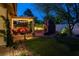 Inviting backyard showcasing a stone fireplace, pergola with seating, string lights, and well-manicured lawn at 1432 Castle Crest Dr, Las Vegas, NV 89117
