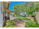 Well-manicured backyard with lush lawn, mature trees, stone pathways, and cozy patio area perfect for outdoor living at 1432 Castle Crest Dr, Las Vegas, NV 89117