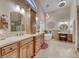 A bright bathroom that features a vanity with double sinks, a soaking tub, and pendant lighting at 1432 Castle Crest Dr, Las Vegas, NV 89117