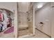 A full bathroom with tiled walk-in shower, bench, and neutral color palette, adjacent to a walk-in closet at 1432 Castle Crest Dr, Las Vegas, NV 89117