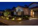 Beautiful single story home with stone accents and desert landscaping illuminated at night at 1432 Castle Crest Dr, Las Vegas, NV 89117