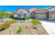 Charming home featuring a desert landscape, stone accents, and a red tile roof under a sunny blue sky at 1432 Castle Crest Dr, Las Vegas, NV 89117