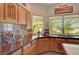 Spacious kitchen with wooden cabinets, tile backsplash, and a large window overlooking the backyard at 1432 Castle Crest Dr, Las Vegas, NV 89117