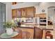 Well-lit kitchen with wooden cabinets, stainless steel appliances, and a cozy dining area at 1432 Castle Crest Dr, Las Vegas, NV 89117