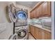 Convenient laundry room with modern stacked washer and dryer, ample storage, and a utility sink at 1432 Castle Crest Dr, Las Vegas, NV 89117