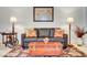 Cozy living room featuring a leather sofa, decorative lamps, and a patterned rug, creating a welcoming atmosphere at 1432 Castle Crest Dr, Las Vegas, NV 89117
