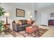 Warm living room with leather sofa, floral-patterned rug, and views of entryway at 1432 Castle Crest Dr, Las Vegas, NV 89117