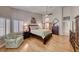 Bright main bedroom featuring hardwood floors, shuttered windows, ceiling fan, and a sitting area at 1432 Castle Crest Dr, Las Vegas, NV 89117