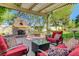 Charming outdoor patio with a cozy fireplace, comfortable seating, and a lush, landscaped backyard at 1432 Castle Crest Dr, Las Vegas, NV 89117