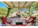 Relaxing outdoor patio featuring a stone fireplace, comfortable seating, and a pergola for shade at 1432 Castle Crest Dr, Las Vegas, NV 89117