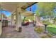 Inviting covered patio with outdoor seating and view of the backyard's stone fireplace at 1432 Castle Crest Dr, Las Vegas, NV 89117