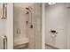Modern bathroom shower with glass door, bench, and neutral tile at 1432 Castle Crest Dr, Las Vegas, NV 89117