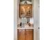 Stylish wet bar featuring custom cabinetry, countertop, mirrored backsplash, and glassware display at 1432 Castle Crest Dr, Las Vegas, NV 89117