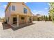 A spacious backyard featuring a covered patio, neutral gravel, and decorative metal garden seating at 1540 Singing Bird Ln, North Las Vegas, NV 89031