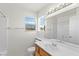 Bright bathroom with a large mirror, white vanity and shower over tub at 1540 Singing Bird Ln, North Las Vegas, NV 89031