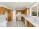 Well-lit kitchen with oak cabinetry, white appliances, and a window overlooking the backyard at 1540 Singing Bird Ln, North Las Vegas, NV 89031
