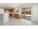 Efficient kitchen features tile flooring, wood cabinets, and sliding door access to the patio at 1540 Singing Bird Ln, North Las Vegas, NV 89031