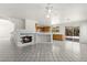 Open-concept living space with fireplace, tile flooring, ceiling fan, and access to kitchen and patio at 1540 Singing Bird Ln, North Las Vegas, NV 89031
