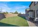 Large backyard with lush artificial turf, patio area, and privacy wall, creating a tranquil outdoor retreat at 232 Delighted Ave, North Las Vegas, NV 89031
