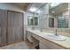 Bright bathroom featuring double sinks, ample vanity space, and a tiled shower at 2531 La Cara Ave, Las Vegas, NV 89121