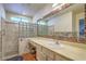 Bathroom featuring a tiled shower, glass block window and large vanity at 2531 La Cara Ave, Las Vegas, NV 89121
