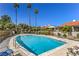 Community pool surrounded by lush landscaping with lounge chairs and clear blue water for relaxation at 2531 La Cara Ave, Las Vegas, NV 89121