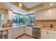 Bright kitchen featuring white cabinets, tile backsplash, and a large window overlooking the backyard at 2531 La Cara Ave, Las Vegas, NV 89121