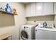 Functional laundry area with washer, dryer, storage shelves, and built-in cabinetry at 2531 La Cara Ave, Las Vegas, NV 89121