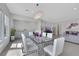Open dining area with a glass table, gray cabinetry, and view to the living room at 3005 Merlesco Ave, Henderson, NV 89044
