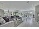 Open living space with gray sofa, glass table, and dining area with natural light at 3005 Merlesco Ave, Henderson, NV 89044