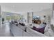 Modern living room featuring a large gray sofa, glass table, and open floor plan to the dining area at 3005 Merlesco Ave, Henderson, NV 89044
