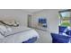 Sunlit main bedroom featuring a blue bed, mirrored dresser, and comfortable blue bench by the window at 3005 Merlesco Ave, Henderson, NV 89044