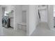 Neutral colored mud room with bench, coat hooks, shelving, modern washer and dryer, and tiled floors at 3005 Merlesco Ave, Henderson, NV 89044