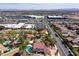 Scenic aerial shot of a neighborhood with shopping centers nearby, pools, tennis court, and mountain views in the background at 3396 Montessouri St, Las Vegas, NV 89117