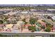 Wide aerial view of a suburban neighborhood with mature trees and a city skyline in the distance at 3396 Montessouri St, Las Vegas, NV 89117
