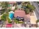 An aerial shot showcasing a residence with a private pool, landscaped backyard, and sports court at 3396 Montessouri St, Las Vegas, NV 89117