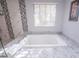 Close-up of elegant tub with marble surround and patterned tile accents for relaxation and style at 3396 Montessouri St, Las Vegas, NV 89117