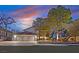 Large home with a three-car garage, mature trees, landscaping, and lighting at 3396 Montessouri St, Las Vegas, NV 89117