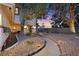 Charming front yard with walkway, decorative rock, mature trees, and exterior lighting at 3396 Montessouri St, Las Vegas, NV 89117