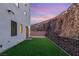 The backyard features a low-maintenance artificial grass lawn and a private setting with a view of the adjacent hillside at 350 Solitude Peak Ln, Henderson, NV 89012