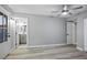 Bedroom with hardwood floors, a ceiling fan, and a door leading to a bathroom, offering comfort and privacy at 3531 W Arby Ave, Las Vegas, NV 89118