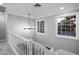 Stairway with white railings and a decorative light fixture, enhanced by natural light streaming through the windows at 3531 W Arby Ave, Las Vegas, NV 89118
