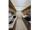 Traditional kitchen featuring tile flooring, wooden cabinets, and essential appliances at 3585 Arville St # 401A, Las Vegas, NV 89103