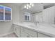 Bathroom featuring dual sinks with white cabinets, stone countertop and a shower/tub combo at 3604 N Campbell Rd, Las Vegas, NV 89129